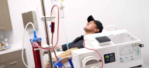 Patient receiving EBOO therapy with blood filtration and ozone machine in a clinical setting